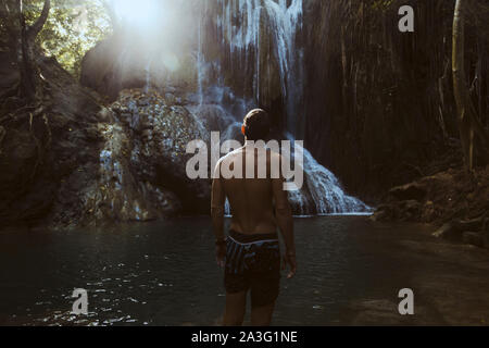 Man standing near waterfall Stock Photo