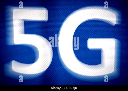 08 October 2019, Lower Saxony, Hanover: 5G is on a poster at the 5G CMM Expo. The trade fair, where visitors can get an insight into the technical possibilities of the new mobile radio standard 5G, will take place from 08 - 10 October 2019. Photo: Sina Schuldt/dpa Stock Photo