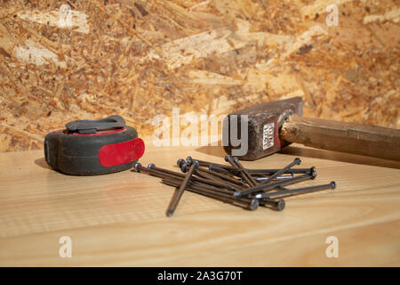 Hammer nails and tape measure on wooden table Stock Photo