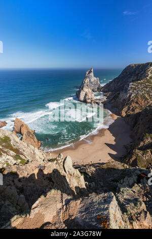 View of Atlantic Ocean, coastline with huge boulders and Praia da Ursa beach near Cabo da Roca, the westernmost point of mainland Europe in Portugal.