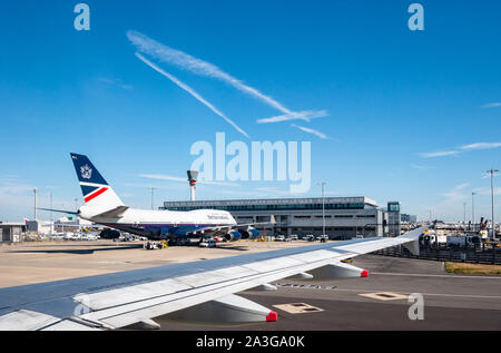 View from plane window of airport apron with British Airways Jumbo Jet, Terminal 5, Heathrow Airport, London, England, UK Stock Photo