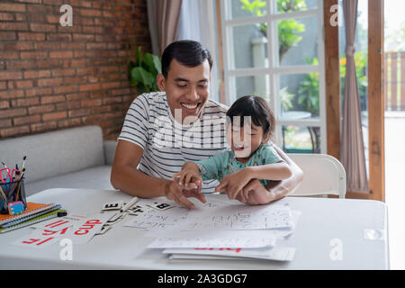portrait of asian toddler studying with her father at home. Stock Photo