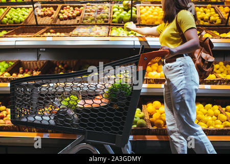 woman at grocery store market with shopping cart Stock Photo