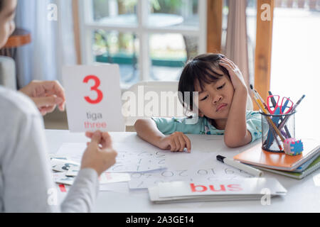 tired and bored toddler while studying with mother at home Stock Photo