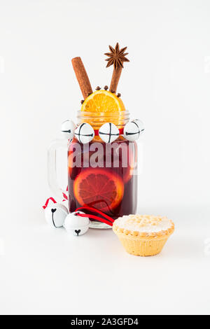 Mason jar filled with mulled wine and a mince pie with Christmas decoration on white background with copy space. Stock Photo