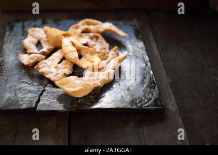 Angel wings.Traditional shortbread crepes with powdered sugar, regional carnival sweets. Stock Photo