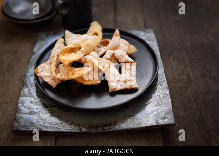 Traditional shortbread crepes with powdered sugar, regional carnival sweets. Stock Photo