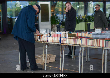 Old person choosing book from a second hand book shop installed in the street Stock Photo