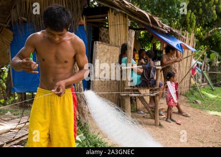 Philippines, Palawan, Malampaya Sound Protected Landscape and Seascape, boy repairing fishnet Stock Photo