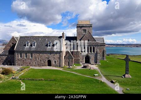 United Kingdom, Scotland, Highland, Inner Hebrides, Isle of Iona facing the Isle of Mull, Iona abbey founded by Saint Columba in the 6th century and St. Martin's Cross on the right Stock Photo