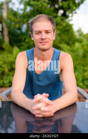 Young handsome man with blond hair relaxing outdoors Stock Photo