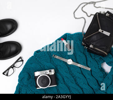 Flat lay top view female casual style look with warm turquoise sweater, jeans, boots, watch, glasses and purse Stock Photo