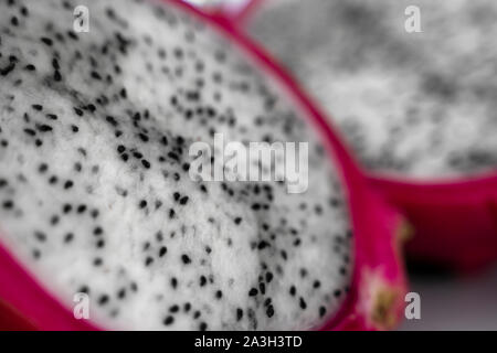 Dragon fruit. Vibrant Dragon Fruit on white background. Sliced white dragon fruit or pitaya on white plate on the table, close-up. Tropical and exotic Stock Photo