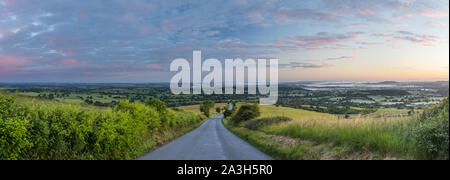 The road to Okeford Fitzpaine; dawn on the longest day in the Blackmore Vale, from Okeford Hill, Dorset, England, UK Stock Photo