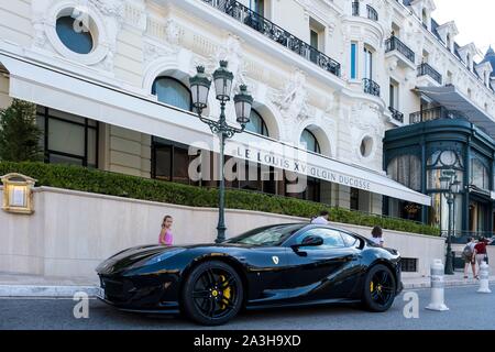 Principalty of Monaco, Monaco, Monte Carlo, Hotel de Paris, luxury hotel, property of the Societe des Bains de Mer overlooking on Place du Casino with Le Louis XV gastronomic restaurant owned by Alain Ducasse, luxury car Stock Photo