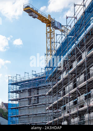 Scaffolding at the house construction site with crane Stock Photo