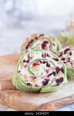 Fresh homemade cranberry pinwheels made with cream cheese, dried cranberries, walnuts, goats cheese and rosemary ready for the holidays. Stock Photo