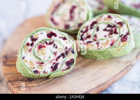 Fresh homemade cranberry pinwheels made with cream cheese, dried cranberries, walnuts, goats cheese and rosemary ready for the holidays. Stock Photo