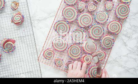 Step by step. Flat lay. Cooling freshly baked bake red, white, and blue pinwheel sugar cookies on a cooling rack. Stock Photo