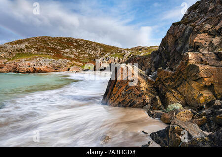 Remote beach on the shore of Achmelvich Bay in Assynt, Sutherland in North West Scottish Highlands note massive Lewisian gneiss boulder in foreground Stock Photo