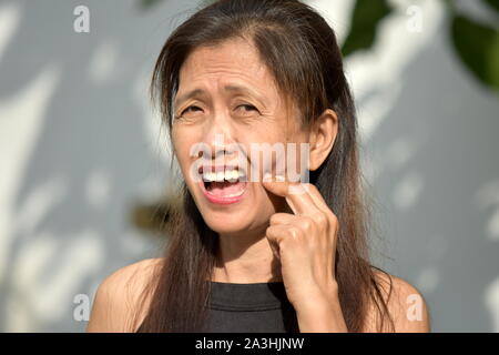 An Old Filipina Grandma With Toothache Stock Photo