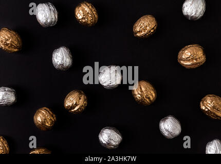 Painted golden and silver walnuts on black background Stock Photo