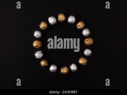 Painted golden and silver walnuts on black background Stock Photo