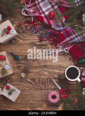 Hot Christmas Beverage Cocoa or Chocolate or Coffee in Small Cup with Presents Boxes Cord Sparkles Fir Tree Branch Nuts on Wooden Background. Winter T Stock Photo