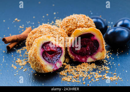 Plum dumplings. Traditional homemade sweet plum dumplings with crumble and cinnamon. Stock Photo