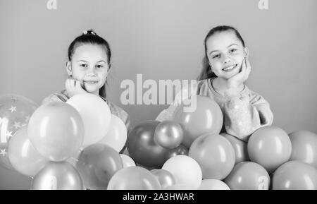 Happiness and cheerful moments. Carefree childhood. Sisters organize home party. Having fun concept. Balloon theme party. Girls best friends near air balloons. Start this party. Birthday party. Stock Photo