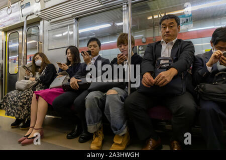 Tokyo, Japan - october 30th, 2018: Train passengers in Tokyo, most of them concentrated in their cellphones Stock Photo