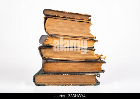 Old dusty books on a light countertop. Library items in old bindings. White background. Stock Photo