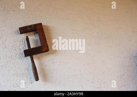 Antique wooden screw clamp hanging on a wall Stock Photo