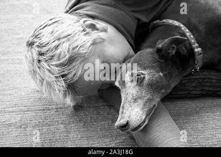 True love old woman and old dog sleeping on floor, North Yorkshire, England, UK, GB Stock Photo