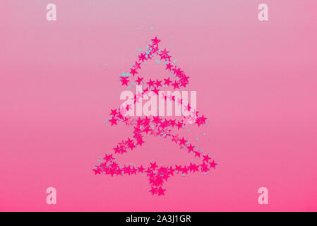 Christmas Tree made from stars on bright pink background Stock Photo