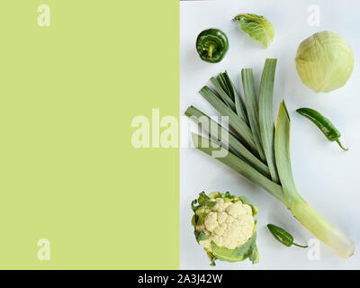 Creative layout made of zucchini leek cauliflower green and chili pepper . Flat lay. Food concept. Green vegetables isolated on white-green background Stock Photo