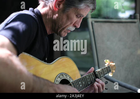 An older man playing guitar.