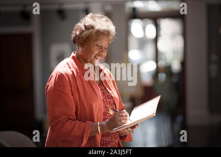 Mature adult woman writing in a notebook. Stock Photo