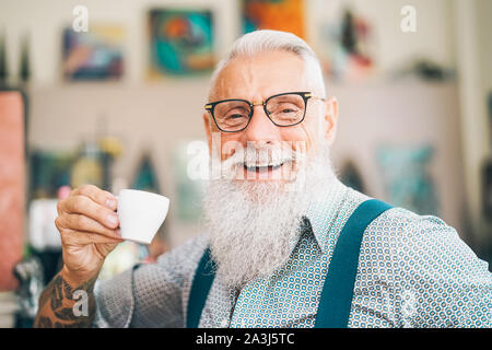 Happy senior drinking coffee in bar - Hipster older male having coffee break - Lifestyle people concept Stock Photo