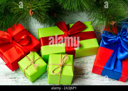 Christmas composition. Many multi-colored gift boxes under the Christmas tree on a wooden floor near fir branches. View from above. a Christmas gift Stock Photo