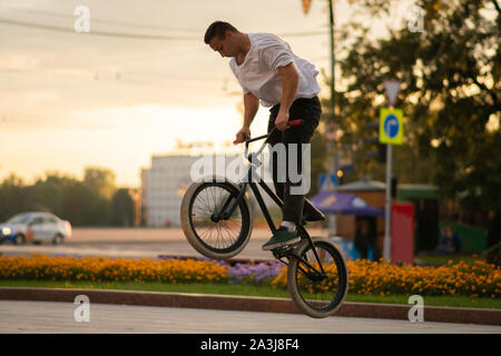The guy performs a stunt on BMX, jumping high up. Stock Photo