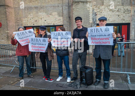 London, UK. 8th October 2019. Protesters pose with posters 'RIBA - Royal Institure of Billionaires' Arselickers. Credit: Peter Marshall/Alamy Live News Stock Photo