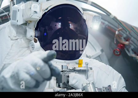Astronaut in a spacesuit. Point finger forward. Elements of this image were furnished by NASA. Stock Photo