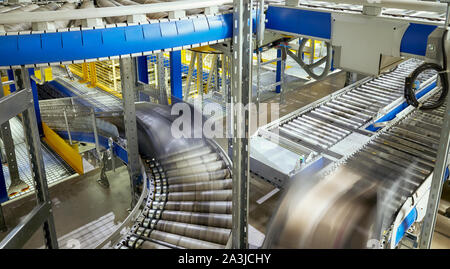 Picture of a transportation line conveyor roller with containers in motion. Stock Photo