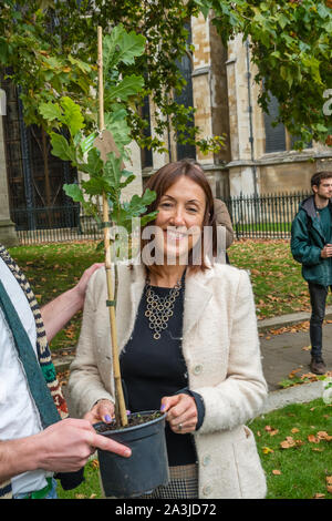 London, UK. 8th October 2019. Liberal Democrat MP for Brecon and Radnorshire Jane Dodds collects an English Oak. Campaigners bring 1000 native trees in pots to Old Palace Yard with labelled for MPs, world leaders and others, inviting MPs to come and collect their tree. The symbolic action called on the government and MPs to plant billions of trees across the UK, and support the planting of trillions more around the world. Credit: Peter Marshall/Alamy Live News Stock Photo