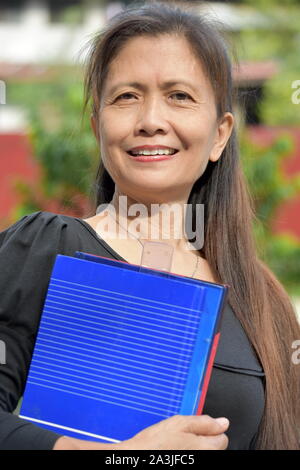 Intelligent Minority Female Teacher Smiling With Notebooks Stock Photo