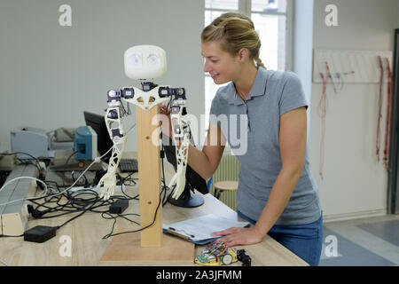 a woman fixing robotic arm Stock Photo