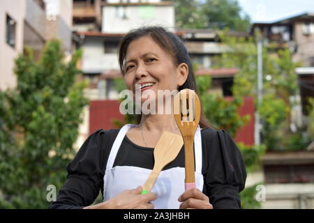 Senior Chef And Happiness Wearing Apron With Utensils Stock Photo