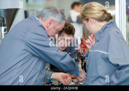 two electronic students in class with teacher Stock Photo