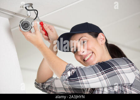 happy female technician fitting cctv camera Stock Photo